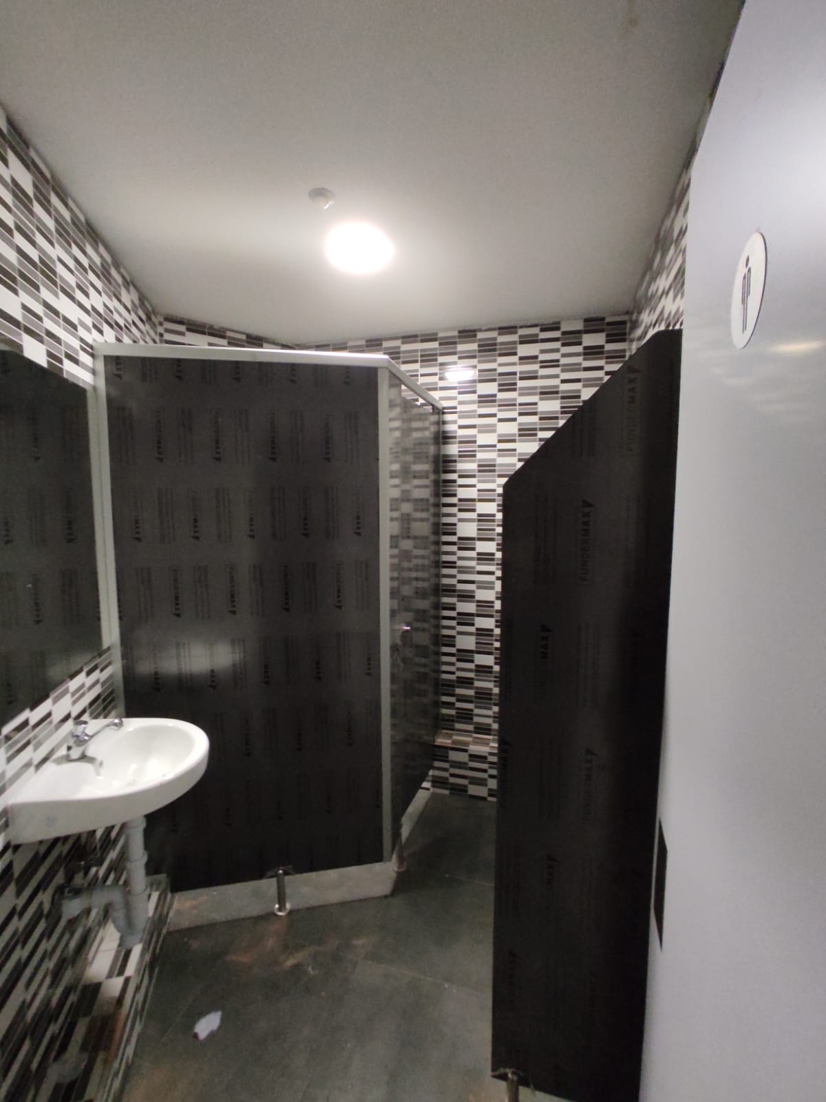 Cabinas sanitarias fenólicas para baño de discoteca en Madrid con separadores de urinario