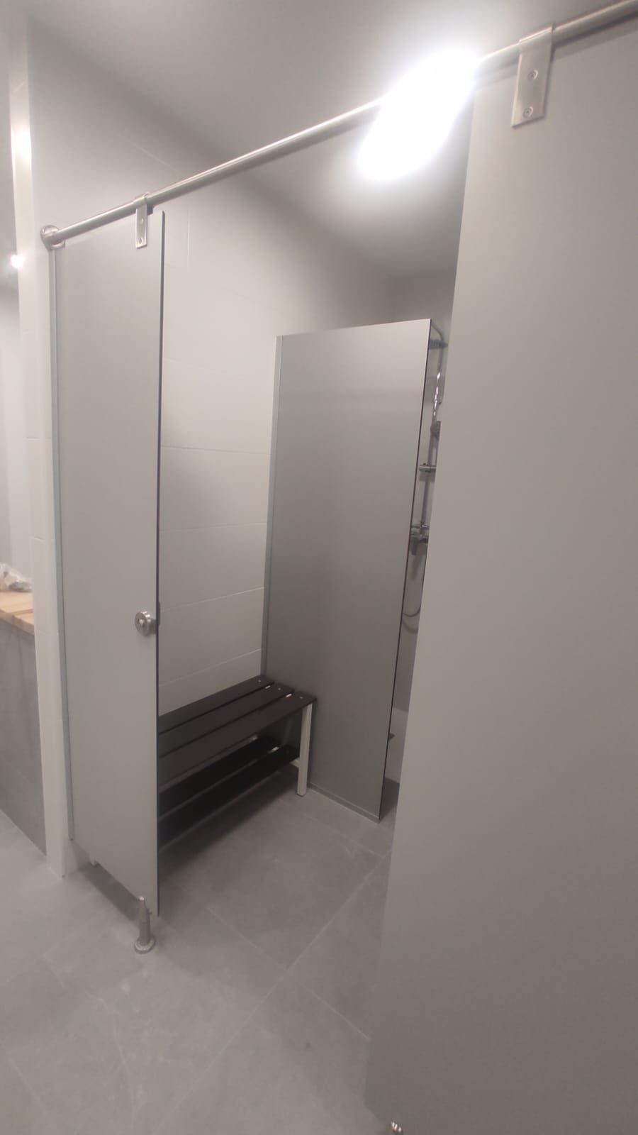Detalle de estructura y fijaciones en cabina de ducha fenólica instalada en Alicante